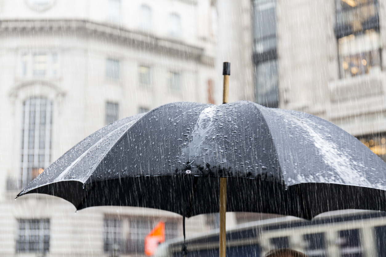 Large black umbrella under rain in Regent Street London